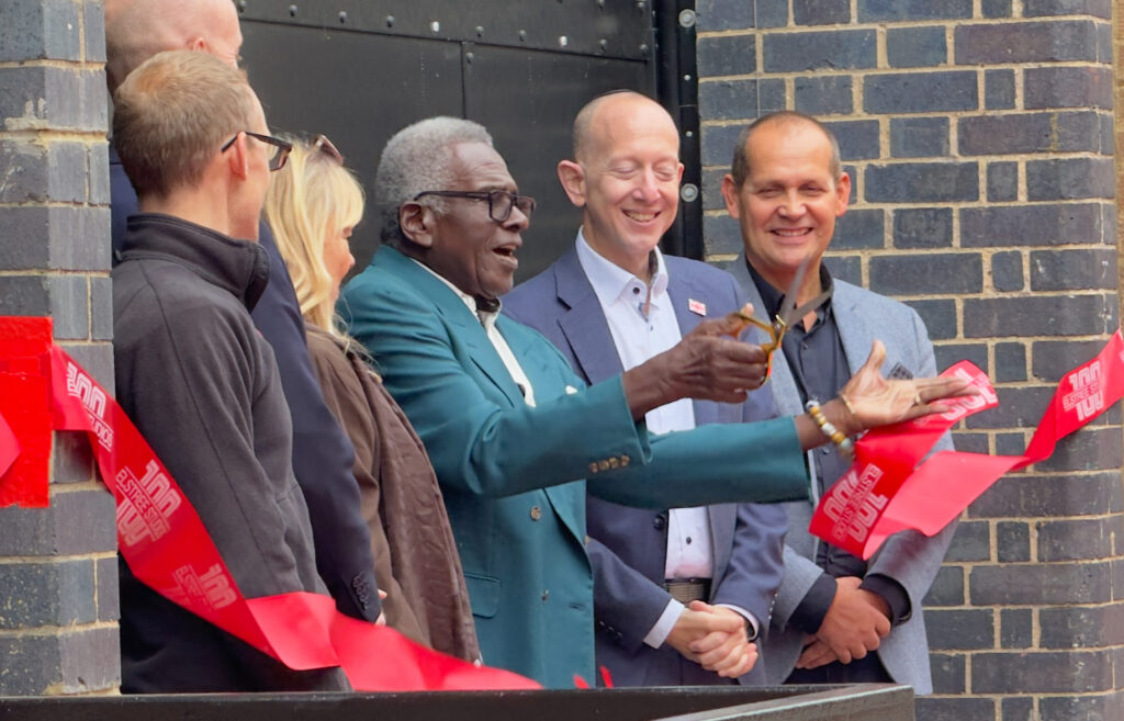 Rudolph Walker and others cut the ribbon outside of the main door for Stage 7 at Elstree Studios.